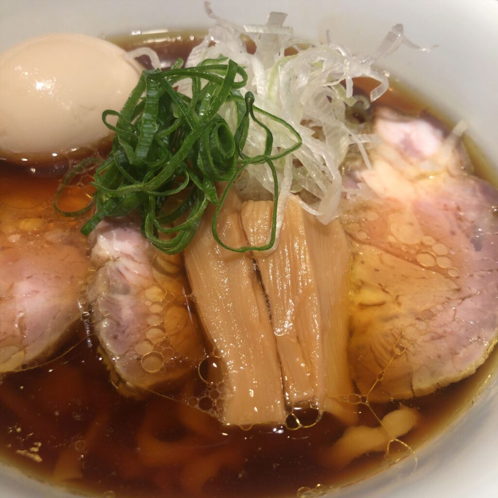 醤油ラーメンのアップ、味玉・チャーシュー・メンマ・ネギが美しく盛り付けられている