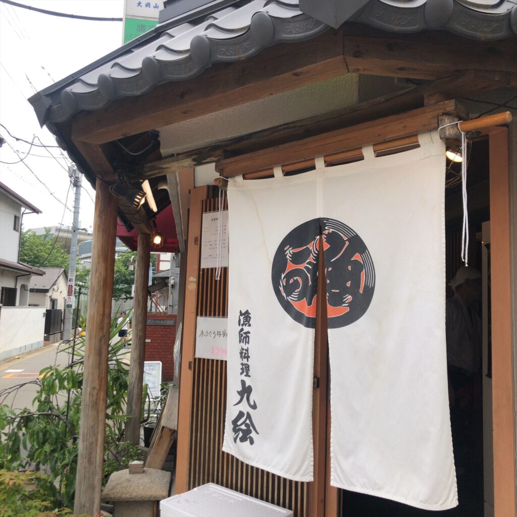 白い暖簾が印象的な九絵の入口