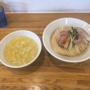 ぬまちゃんラーメンのつけめん澄み。黄金色の鶏清湯スープと、昆布水に浸かった中細麺が美しいつけ麺。チャーシューとカイワレがトッピングされている。