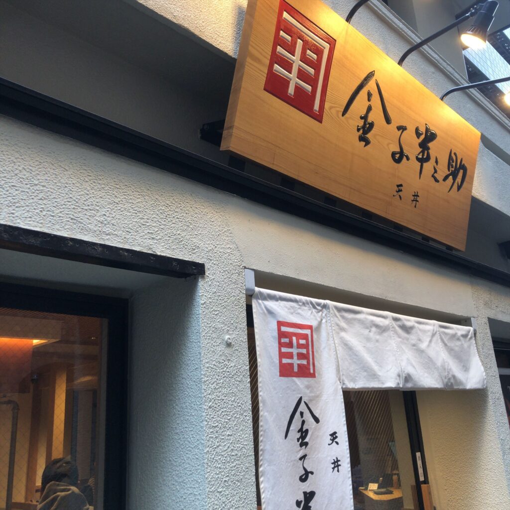 日本橋 天丼 金子半之助 築地本店の外観。木製看板と白い暖簾が目印の天丼専門店